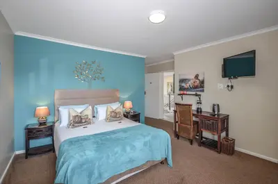 a bedroom with a large bed and a flat screen tv at Atlantic Breeze in Cape Town