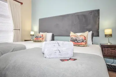 a hotel room with two beds with a towel on the bed at Atlantic Breeze in Cape Town