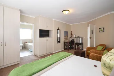 a bedroom with a bed and a living room at Atlantic Breeze in Cape Town