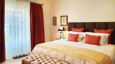 a bedroom with a large bed and a large window at Villa Adalbert Guesthouse in Somerset West