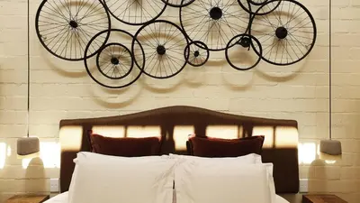 a bicycle on the wall above a bed at Villa Adalbert Guesthouse in Somerset West