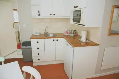 a small kitchen with a sink and a microwave at The Winelands Guest House in Bellville
