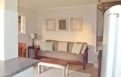 a living room with a couch and a table at The Winelands Guest House in Bellville