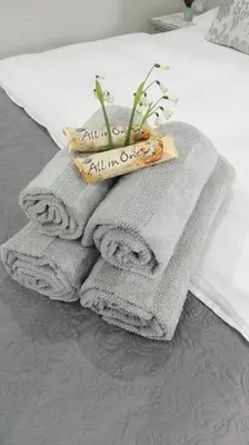 a pile of towels sitting on top of a bed at Two Vines Romantic Guest Studio in Stellenbosch