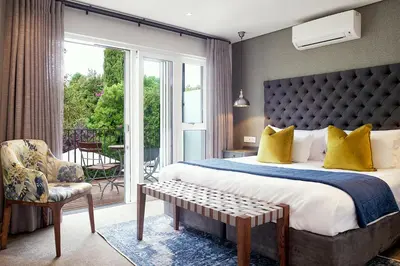 a bedroom with a king sized bed and a balcony at Bonne Esperance Boutique Guest House in Stellenbosch