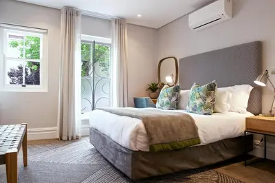 a bedroom with a large bed and a mirror at Bonne Esperance Boutique Guest House in Stellenbosch