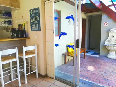 a room with a table and two chairs and a window at Dolphin Inn Blouberg in Bloubergstrand