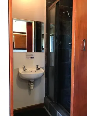 a bathroom with a sink and a shower at Hoogeind Manor in Somerset West