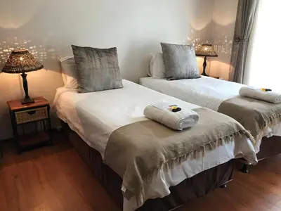 two beds sitting next to each other in a room at Hoogeind Manor in Somerset West