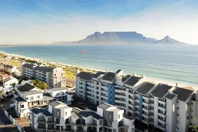 an aerial view of a beach with buildings and the ocean at Aquarius Luxury Suites in Bloubergstrand