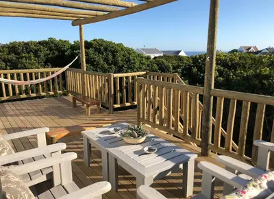 a wooden deck with a table and chairs on it at Renovated Fishermans Cottage in Hermanus