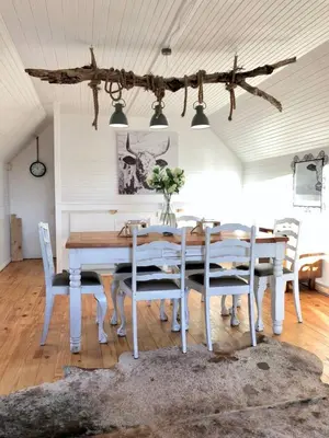 a dining room with a wooden table and chairs at Renovated Fishermans Cottage in Hermanus