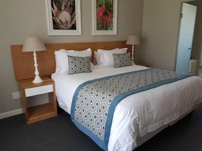 a bedroom with a large white bed with pillows at Pearl Valley Suites in Simondium