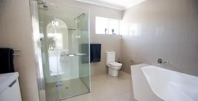 a bathroom with a glass shower and a toilet at Lamabeach city farm in Cape Town