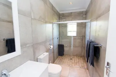 a bathroom with a shower and a toilet at Lamabeach city farm in Cape Town
