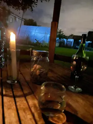 a table with a candle and a bottle of wine at Lamabeach city farm in Cape Town