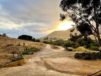 a dirt road with a mountain in the background at Swaynekloof Farm in Botrivier