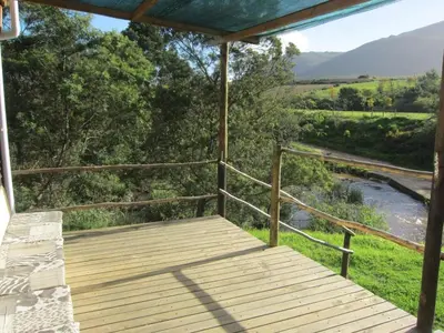 a wooden deck with a view of a river at Swaynekloof Farm in Botrivier