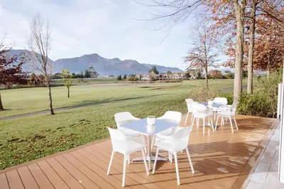 a group of tables and white chairs on a patio at Boschenmeer House in Paarl
