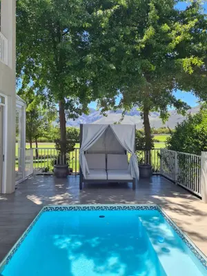 a swimming pool with a tent on a patio at Boschenmeer House in Paarl