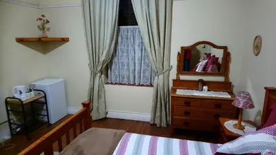 a bedroom with a bed and a mirror and a dresser at Welterusten Guesthouse in Strand
