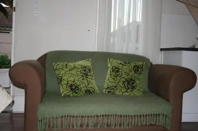 a green couch with two pillows on it at Glen Lilly Self Catering in Parow