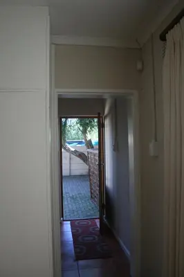 a hallway with a door leading to a yard at N-One Self Catering in Goodwood