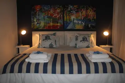 a bedroom with a bed with two towels on it at Merci Pére in Gordonʼs Bay