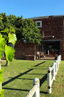 a wooden fence in front of a brick building at African Adventures Accommodation in Joostenberg Vlakte