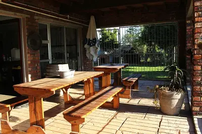 a wooden table and benches on a patio at African Adventures Accommodation in Joostenberg Vlakte