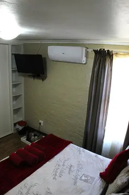 a bedroom with a bed with a television and a window at African Adventures Accommodation in Joostenberg Vlakte