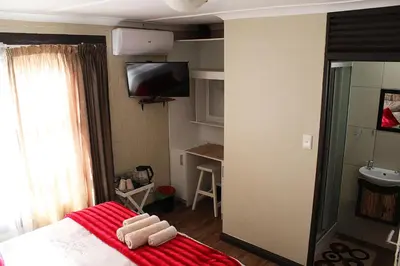 a bedroom with a bed with a red blanket at African Adventures Accommodation in Joostenberg Vlakte