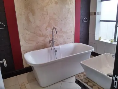 a bath tub with a faucet in a bathroom at African Adventures Accommodation in Joostenberg Vlakte