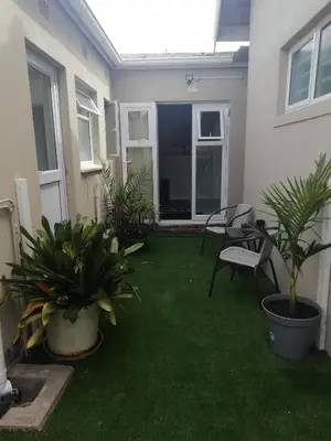a patio with grass and plants in a house at The Palm in Pinelands in Cape Town