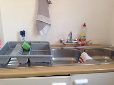 a kitchen sink with a dish drying rack on it at The Palm in Pinelands in Cape Town