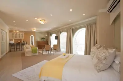 a large bedroom with a large bed and a kitchen at Somerset West Self Catering Vacation Rental - Experience the Best of Cape Town - Wine, Golf, Sea in Somerset West