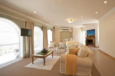 a living room with a couch and a table at Somerset West Self Catering Vacation Rental - Experience the Best of Cape Town - Wine, Golf, Sea in Somerset West