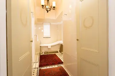 a white bathroom with a tub and a sink at Coopmanhuijs Boutique Hotel & Spa in Stellenbosch