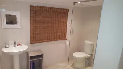 a bathroom with a toilet and a sink and a shower at The Fairway in Cape Town
