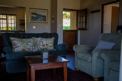 a living room with two couches and a coffee table at Zebra Cottage and Lodge in Stellenbosch