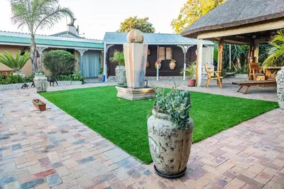 a garden with a large vase with plants in it at De Helling Self Catering in Brackenfell