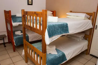 a bedroom with two bunk beds with towels on them at De Helling Self Catering in Brackenfell