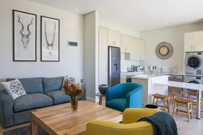 a living room with a couch and a table at Kunjani Villas & Wines in Stellenbosch