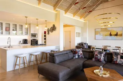 a living room with a couch and a kitchen at Kunjani Villas & Wines in Stellenbosch