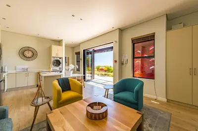 a living room with a table and chairs at Kunjani Villas & Wines in Stellenbosch