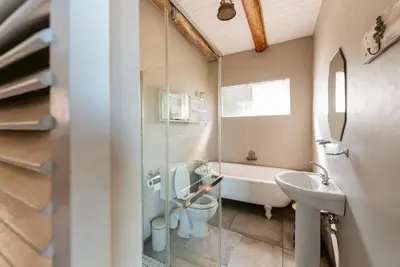 a bathroom with a tub and a toilet and a sink at Dennehof Farm Guesthouse in Villiersdorp