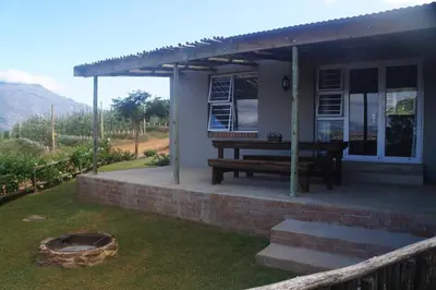 a house with a picnic table in the yard at Dennehof Farm Guesthouse in Villiersdorp