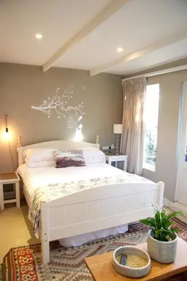 a bedroom with a white bed and a window at The Birdhouse in Cape Town