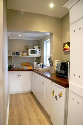 a kitchen with white cabinets and a counter top at The Birdhouse in Cape Town