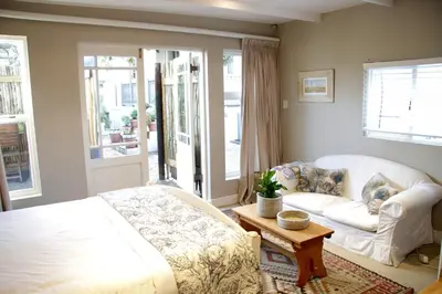 a bedroom with a bed and a couch and a table at The Birdhouse in Cape Town